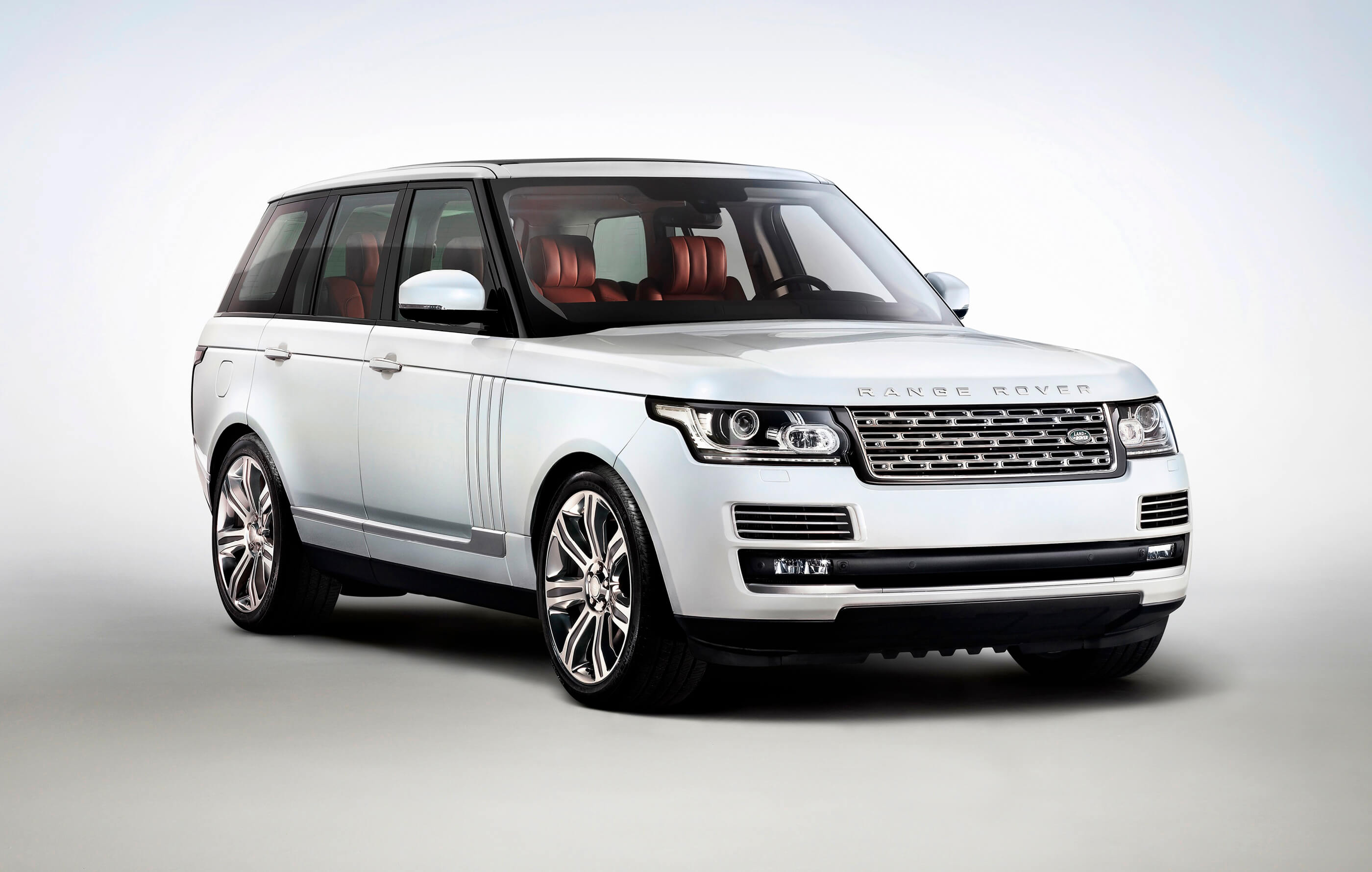 Full screen image of a white Land Rover Range Rover, with red leather interior on a white and grey background