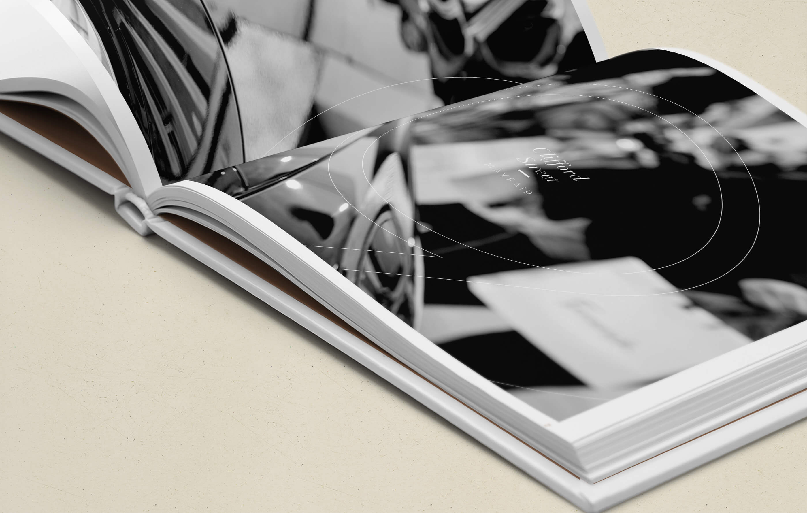 Close-up image of the brochure, featuring a close up black and white shot of a car and 9 Clifford Street logo