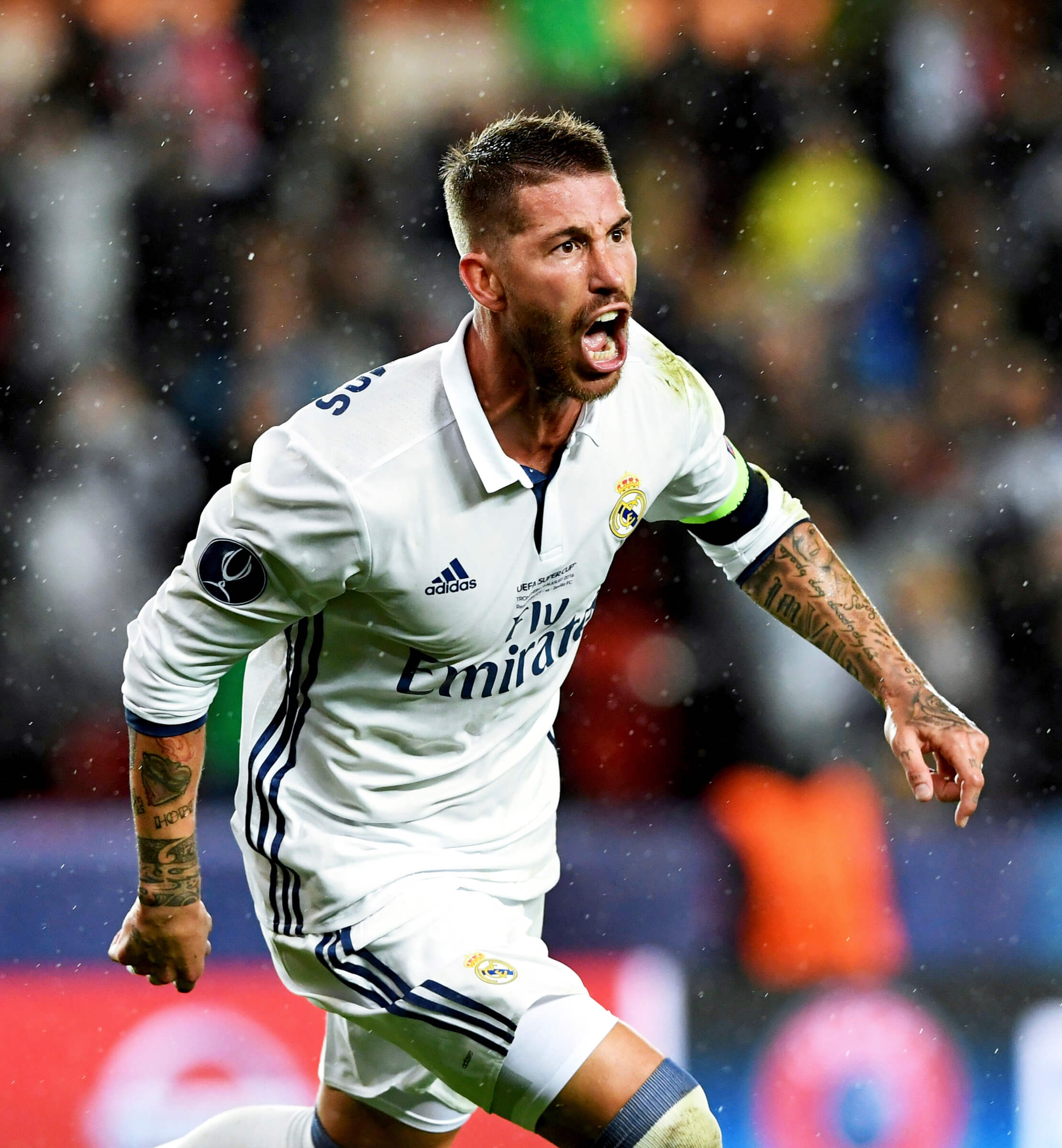 Real Madrid footballer Sergio Ramos wearing a white football shirt and captain's armband, celebrating after scoring a goal