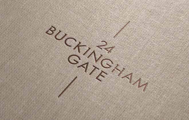 Brown and gold 24 Buckingham Gate logo embossed onto a cloth wrapped brochure cover