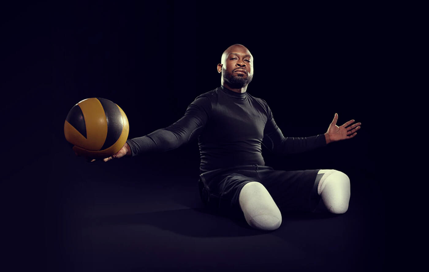 Full screen image of a black male basketball player, ball in hand, on a black background