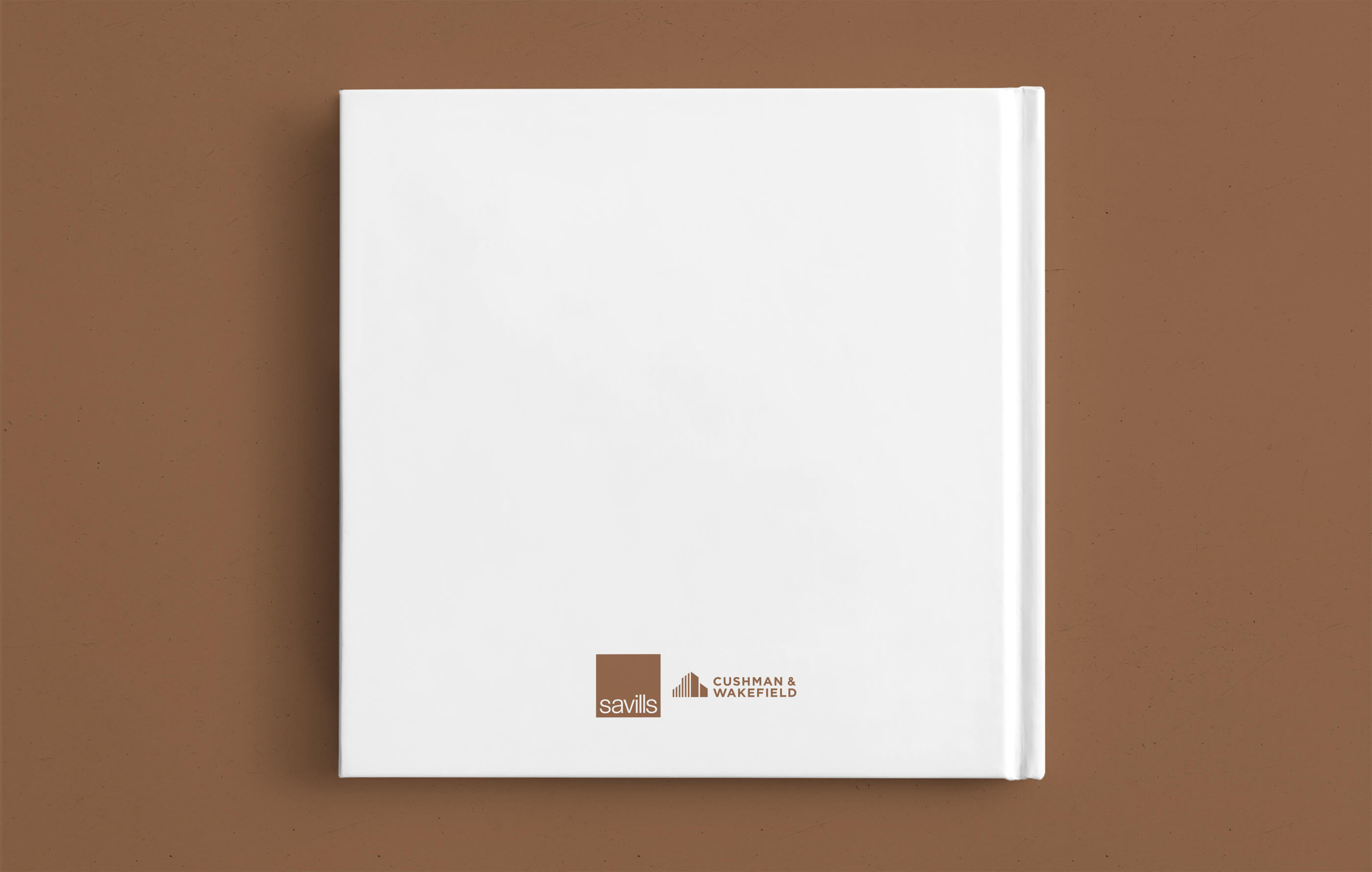 White square hardback brochure for Savills and Cushman & Wakefield, on a dark gold background